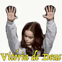 a woman raising her hands in the air with the words vitoria de deus written below her