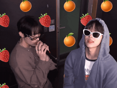 a man wearing sunglasses and a hoodie with strawberries and oranges around him