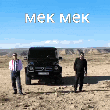 two men are standing in front of a car that says " mek mek " on it