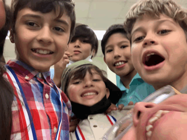 a group of young boys are posing for a picture and one boy is wearing a mask