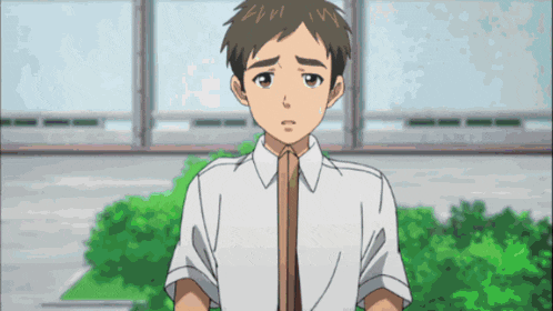 a boy in a white shirt with a brown tie looks sad