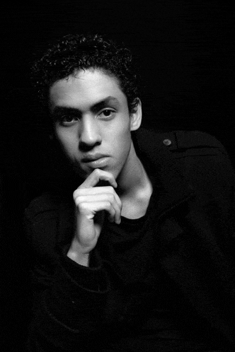 a black and white photo of a young man in a black jacket