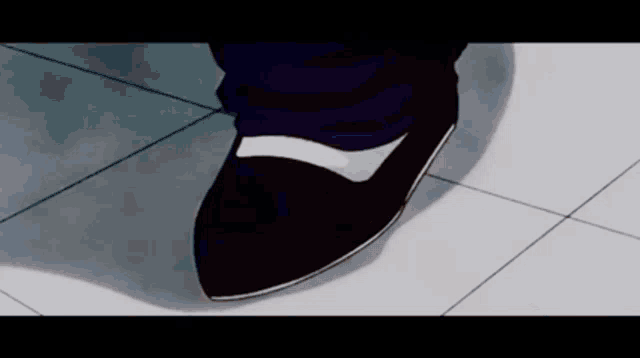 a close up of a person 's foot wearing black shoes .