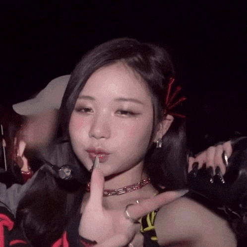 a woman is making a shhh sign with her finger to her lips