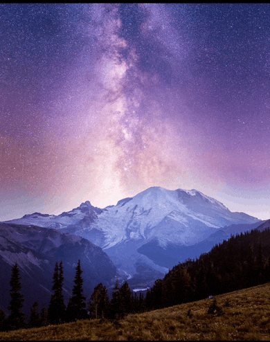 a mountain covered in snow with a purple sky behind it
