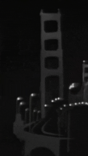 a black and white photo of a bridge in the dark