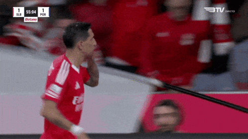 a soccer player wearing a red fly emirates jersey