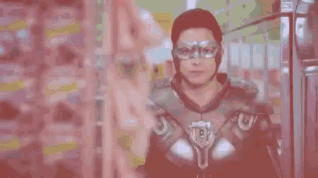 a man in a superhero costume is wearing glasses and a helmet .