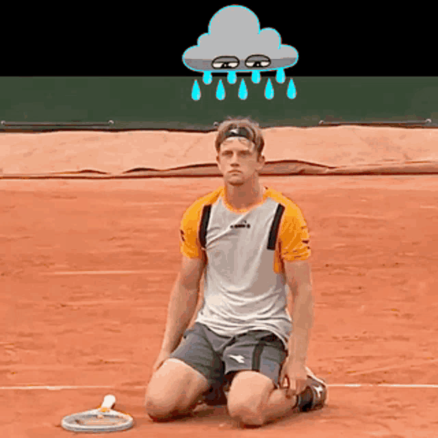 a man is kneeling down on a tennis court with a cloud above his head with rain drops