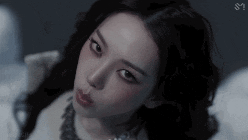 a close up of a woman 's face in a dark room