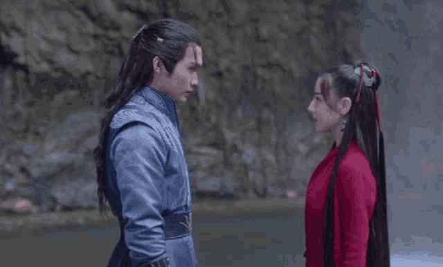 a man and a woman are kissing each other in front of a river .