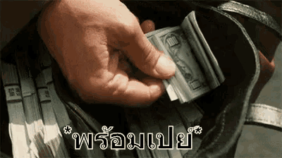 a person is holding a stack of money in their hand