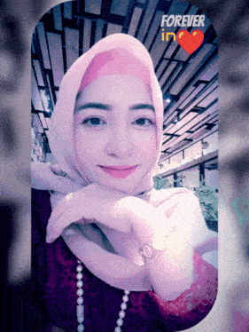 a woman wearing a pink hijab with the words forever in the top right