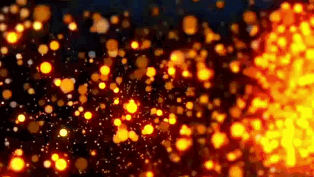 a bunch of orange and yellow lights are flying in the air on a black background .