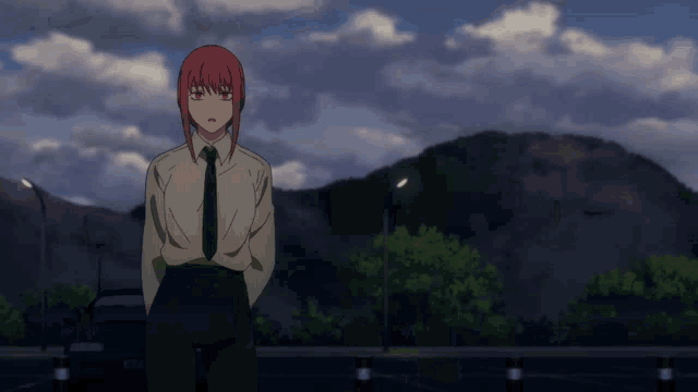 a girl with red hair and a white shirt and tie stands in front of a mountain