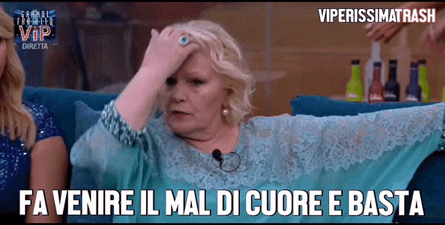 a woman sitting on a couch with the words fa venire il mal di cuore e basta