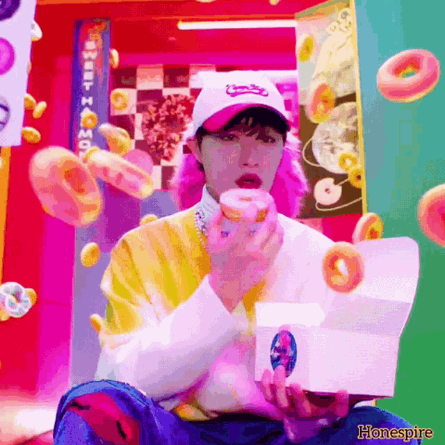 a man is eating a donut in front of a sign that says sweet home .