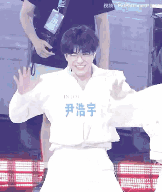 a man wearing glasses and a white shirt with the word into on it