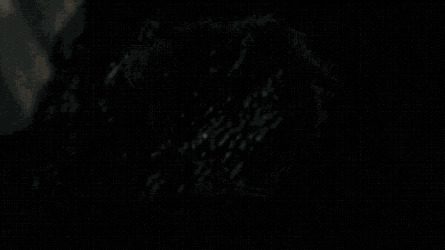 a silhouette of a person in a dark room with a metal wall