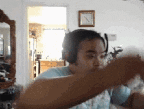 a woman wearing headphones is dancing in a living room