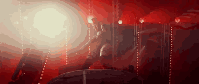 a woman is dancing on a stage in front of a crowd in a dark room .