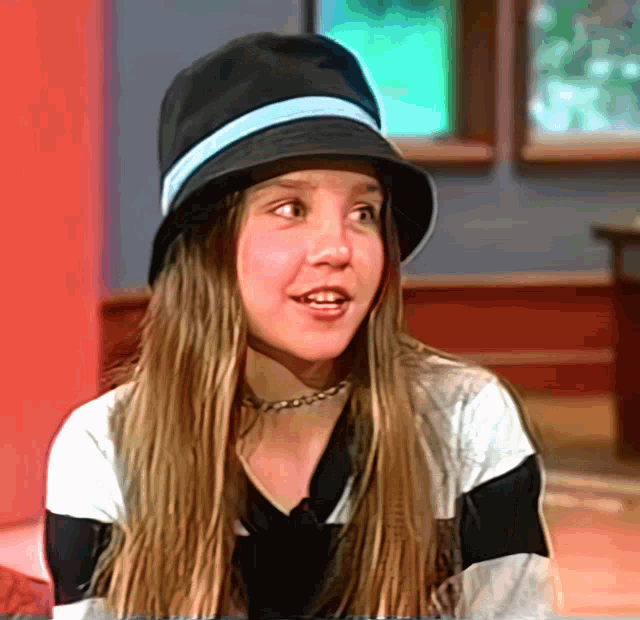a girl wearing a black hat with a blue stripe on it