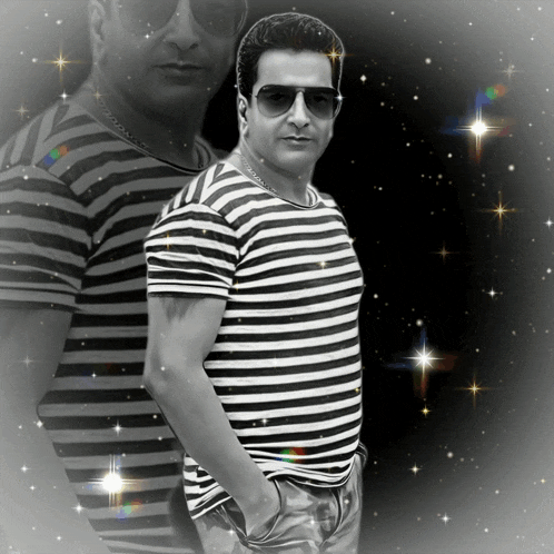 a man wearing sunglasses and a striped shirt stands in front of a starry background