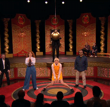 a group of people are standing in a circle on a stage in front of a target