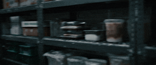 a woman sits in a room with shelves full of boxes that say fresh produce