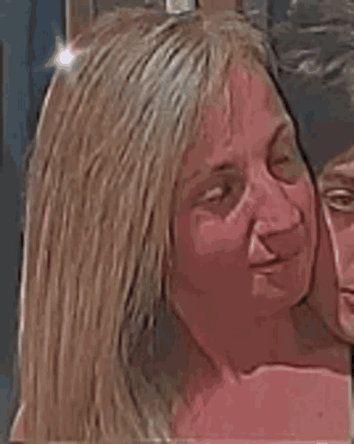 a close up of a woman 's face with a man behind her .