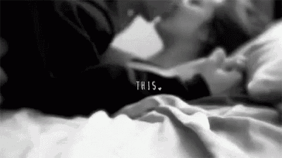 a man and a woman are kissing on a bed .