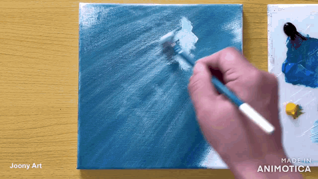 a person is painting on a canvas with the words made in animatica on the bottom right