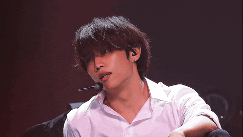 a man wearing a white shirt and a microphone on his ear