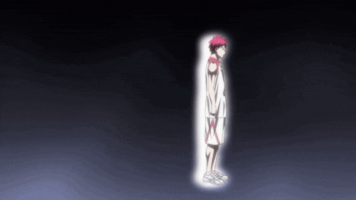a man with red hair is standing in a dark room