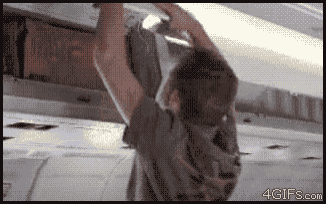 a man is hanging from a ceiling with a 4gifs.com logo in the corner
