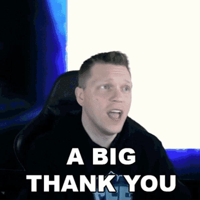 a man is sitting in a chair with his mouth open and says " a big thank you "