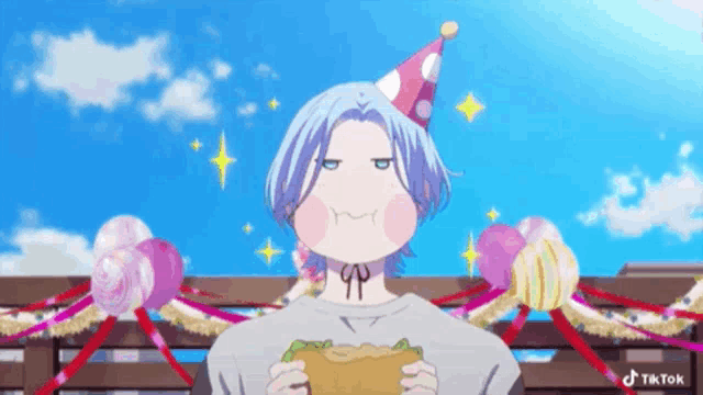 a boy wearing a party hat is eating a hamburger .