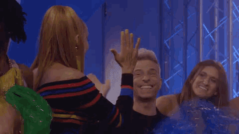 a man and a woman are giving each other a high five while sitting in a crowd .