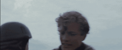 a close up of a person holding another person 's head in a blurry photo .