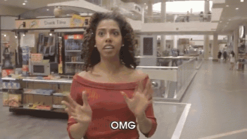a woman in a red top is standing in a mall and says omg