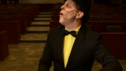 a man in a tuxedo and bow tie is holding a banana in his hand .
