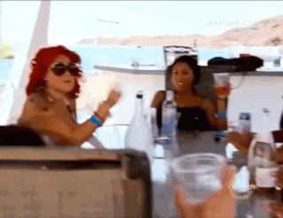 a group of women are sitting at a table with bottles of water