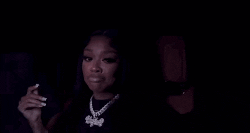 a woman is sitting in the back seat of a car with a man behind her .