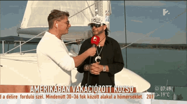 a man on a boat is being interviewed by a news reporter