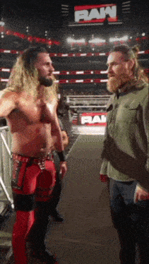 two men are standing next to each other in front of a raw sign