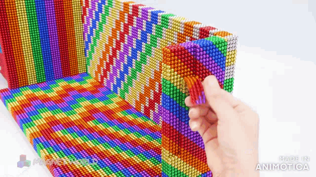 a person is playing with a bunch of colorful magnetic balls