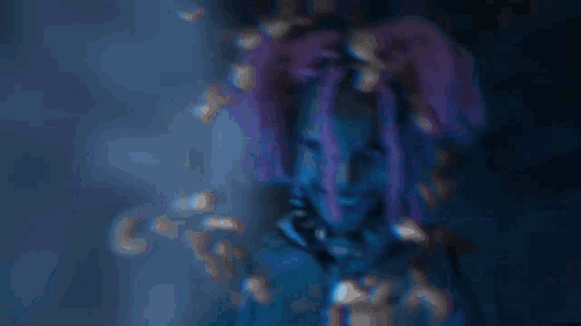 a woman with purple dreadlocks is standing in front of a blue light .