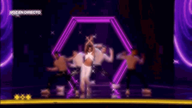 a group of people are dancing on a stage and the words voz en directo are visible