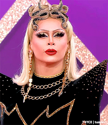a close up of a woman wearing a black and gold outfit
