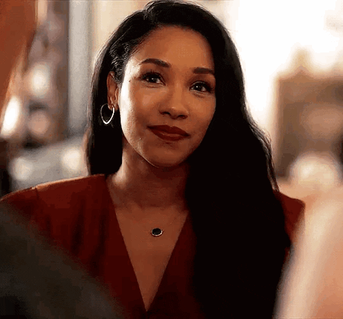 a woman in a red dress and hoop earrings is looking at a man .